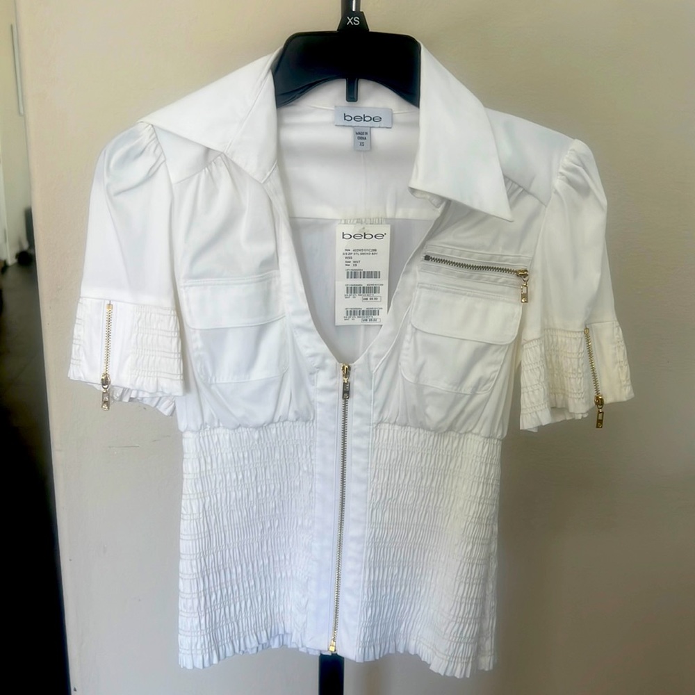 New Bebe white low cut zippered front, sleeves and pocket.